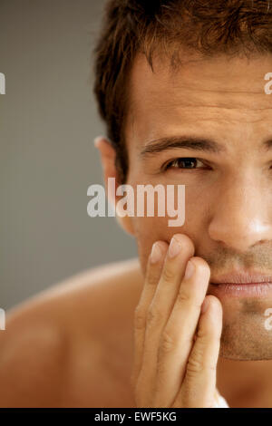 Close-up of young man applying shaving cream Stock Photo