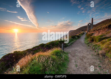 Sunset from the South West Coast Path as it passes the Towanroath engine house and leads toward St Agnes Head on the Cornish coa Stock Photo