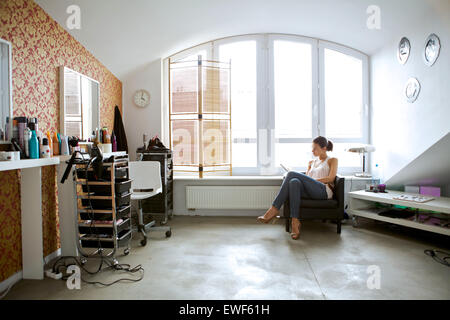 Young woman reading book at beauty spa Stock Photo