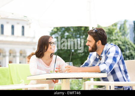 Smiling couple having mojito at sidewalk cafe Stock Photo