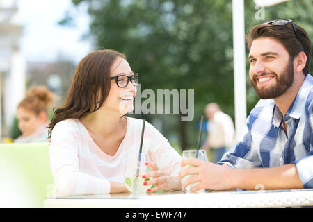 Cheerful couple having mojito at sidewalk cafe Stock Photo