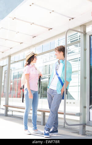 Couple communicating while waiting at bus stop Stock Photo