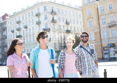 Happy male and female friends walking on city street Stock Photo