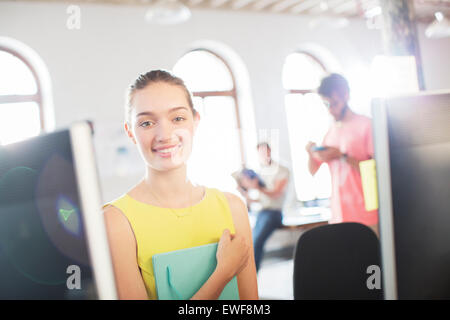Portrait smiling businesswoman at computer in office Stock Photo