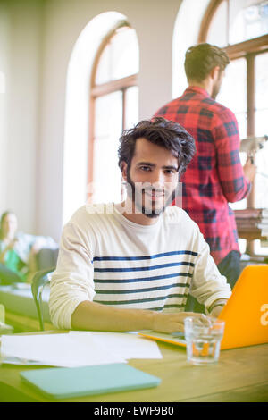 Portrait confident casual businessman using laptop in office Stock Photo