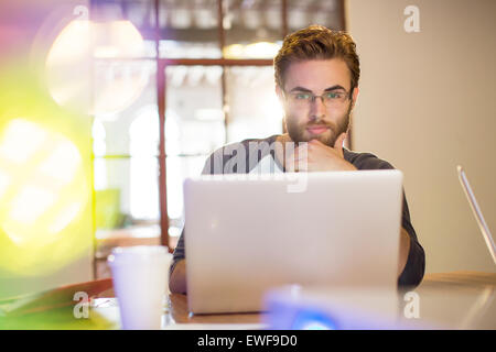 Focused casual businessman working at laptop in office Stock Photo