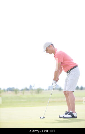 Side view of middle-aged man playing golf at course Stock Photo