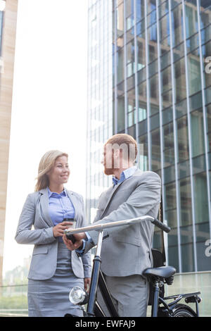 Smiling business couple talking outside office building Stock Photo