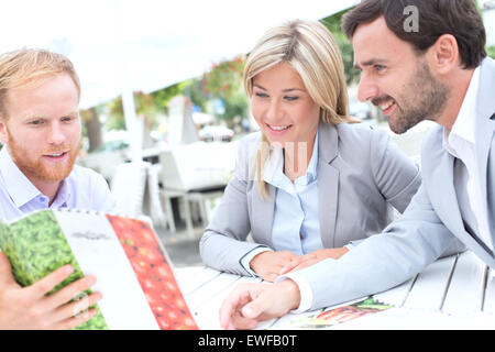 Businesspeople deciding menu at sidewalk cafe Stock Photo