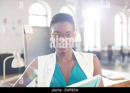 Portrait confident businesswoman wearing eyeglasses in office Stock Photo