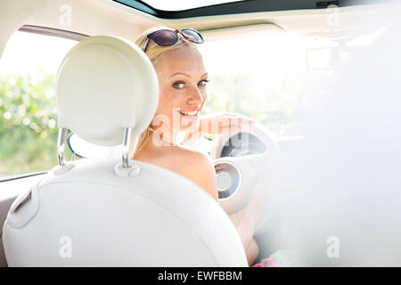 Rear view portrait of happy woman driving car