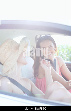 Cheerful female friends enjoying road trip in car Stock Photo