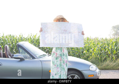 Woman Hiding Face From Hat At Beach Against Sky During Sunset Stock Photo Alamy