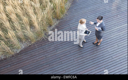 High angle view of businesswomen discussing while standing on floorboard Stock Photo