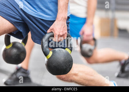 Cropped image of men lifting kettlebells at crossfit gym Stock Photo