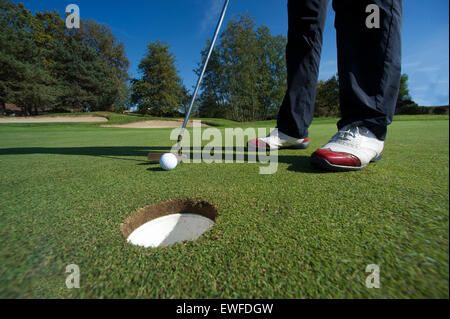 Close up of person putting golf ball on golf course Stock Photo
