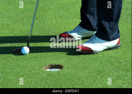 Close up of person putting golf ball on golf course Stock Photo