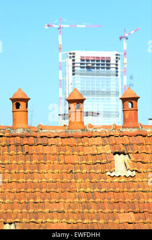 Three old chimney pot with modern construction in the background Stock Photo