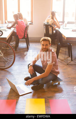 Portrait creative businessman working on laptop on floor Stock Photo