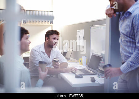 Architects talking and drinking coffee at laptop in office Stock Photo