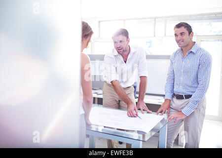 Architects reviewing blueprints in meeting in office Stock Photo