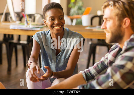 Smiling casual business people talking in office Stock Photo