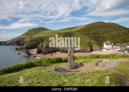 Llangrannog village, statue of St Carannog, beach and cliffs on the Wales Coast path, Ceredigion. Stock Photo