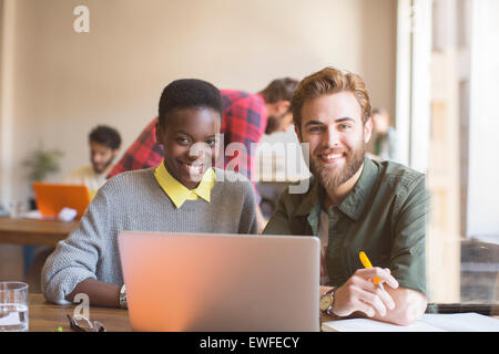 Portrait smiling business people working at laptop in office Stock Photo