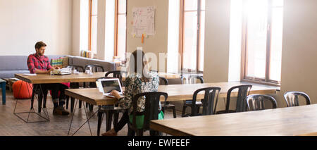 Casual business people working at tables in open office Stock Photo