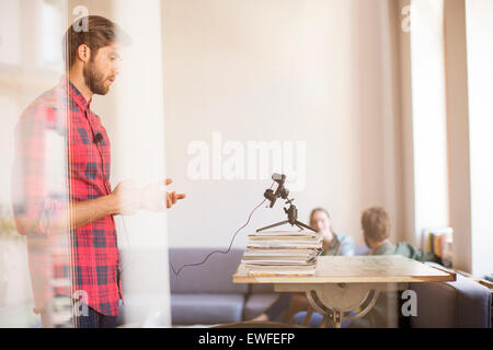 Creative businessman recording video with cell phone in office Stock Photo