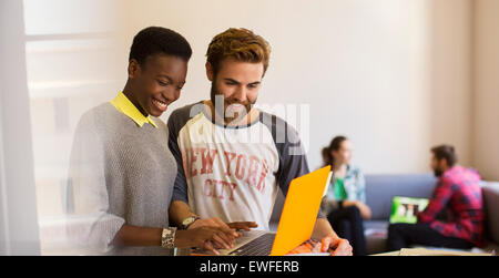 Casual business people sharing laptop in office Stock Photo