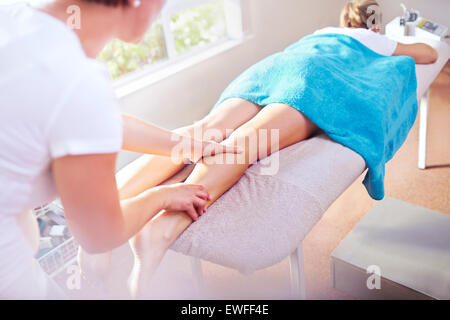 Masseuse massaging woman’s leg Stock Photo