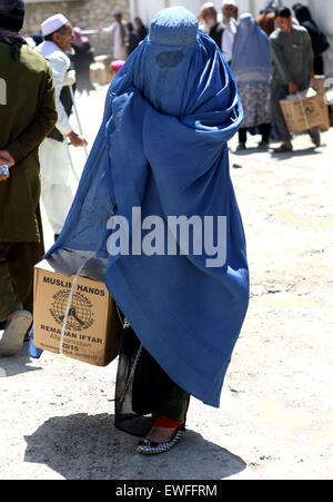 (150625) -- KABUL, June 25, 2015 (Xinhua) -- An Afghan woman carries food donated by Muslim Hands International organization for poor people during the holy month of Ramadan in Kabul, Afghanistan, June 25, 2015. (Xinhua/Ahmad Massoud) Stock Photo
