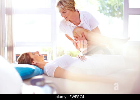 Physical therapist stretching woman’s leg Stock Photo