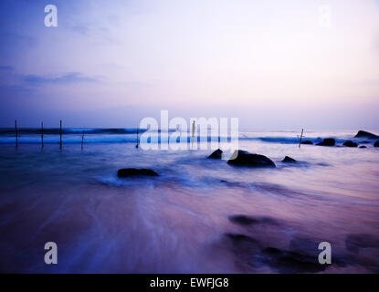 Dreamy Sea coastline, fishing stilts with young boy playing. Stock Photo