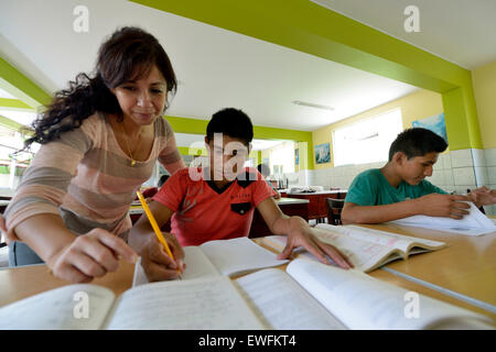 Social worker supporting a teenager, 15 years, former street child, doing homework, Brena, Lima, Peru Stock Photo