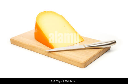 Yellow cheese and kitchen knife on a cutting board against white background Stock Photo