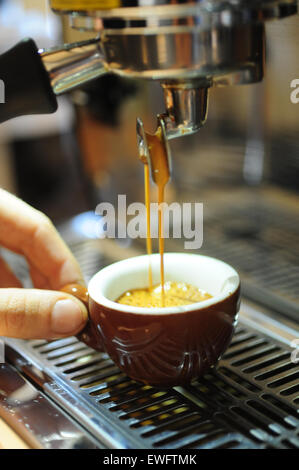 Food Coffee Cafe Espresso beverage served in a demitasse ceramic cup with a barista holding the cup Stock Photo