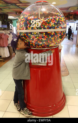 New York, USA, boy embraces a gumball machine