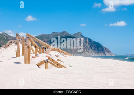 Old police station at Hout Bay reclaimed by sand dunes, Cape Town, South Africa. Sand grains swept into the air is visible over Stock Photo