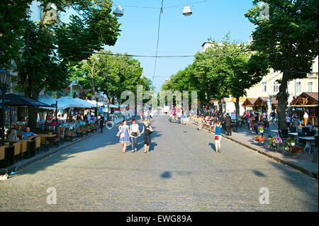 People walking on Deribasovskaya street at sunset. Deribasovskaya street is a famous tourist destination in downtown of Odessa. Stock Photo