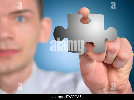 Man with puzzle piece in hand Stock Photo