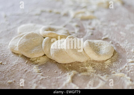 Rolled out dough for dumplings on wooden table Stock Photo