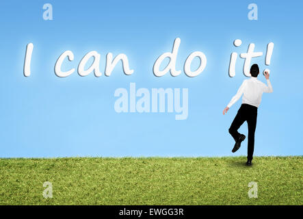 Business man writing on sky I can do it word Stock Photo