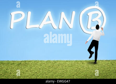 Business man writing on sky Plan B word Stock Photo