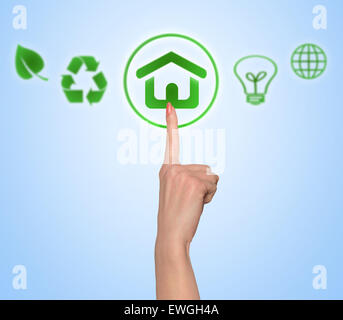 Woman hand push environmental green house button Stock Photo