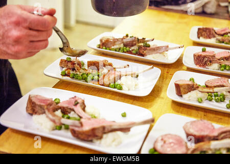 lamb chop plated on a white plate with mash potatoes and pees Stock Photo