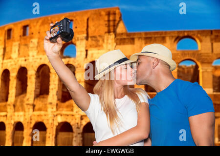Gentle loving couple kissing and taking picture of themselves near beautiful gorgeous ancient Coliseum, honeymoon vacation Stock Photo