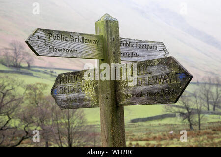 Wooden footpath pointer signpost at Howtown, Lake District national park, Cumbria, England, UK Stock Photo