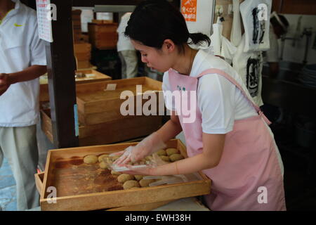 Japanese woman selling japanese pastry (Wagashi) at market Stock Photo